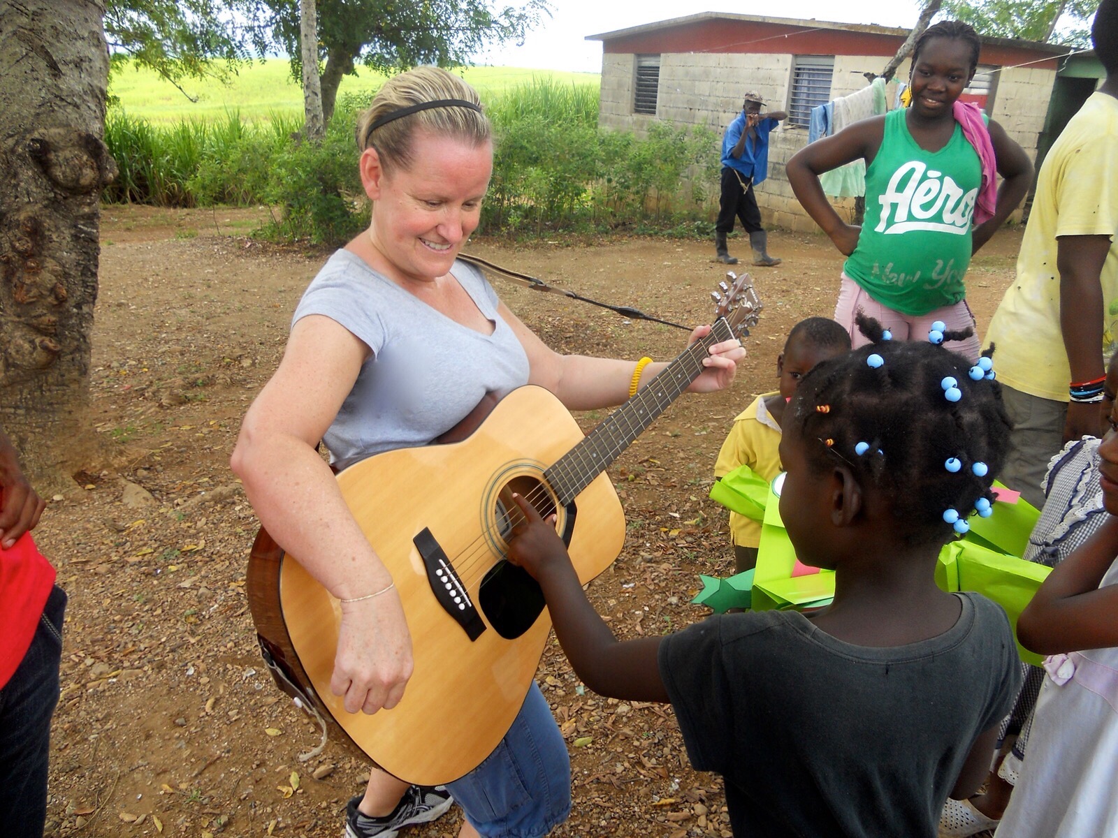 Laurie with children strumming a guitar